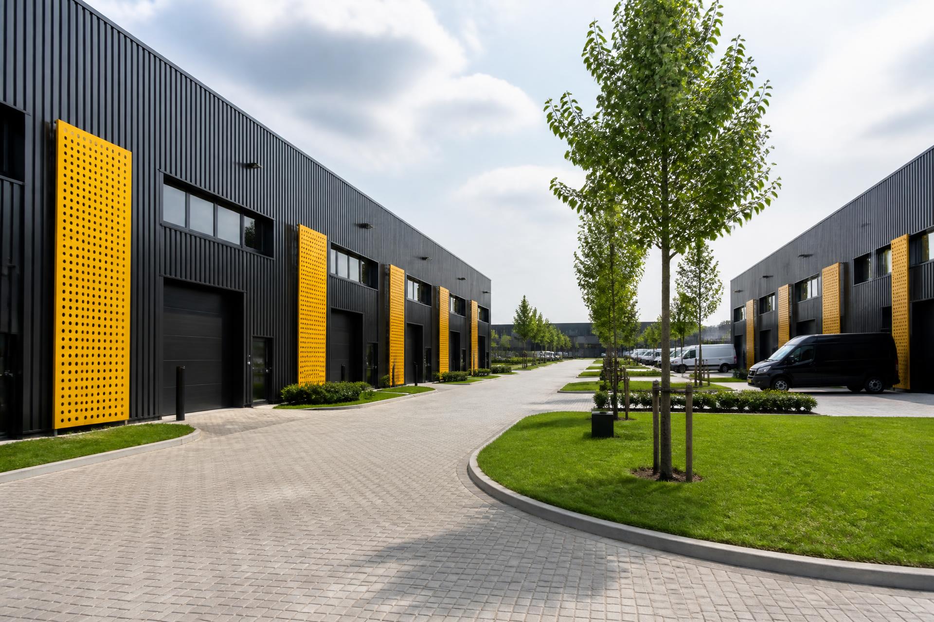 Moderne Nederlandse bedrijfsunits met donkere gevels, grote industriële deuren en gele accentpanelen